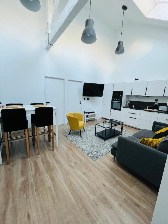 un salon avec un canapé, une table et des chaises dans l'établissement Le Loft - Nantes, à Nantes