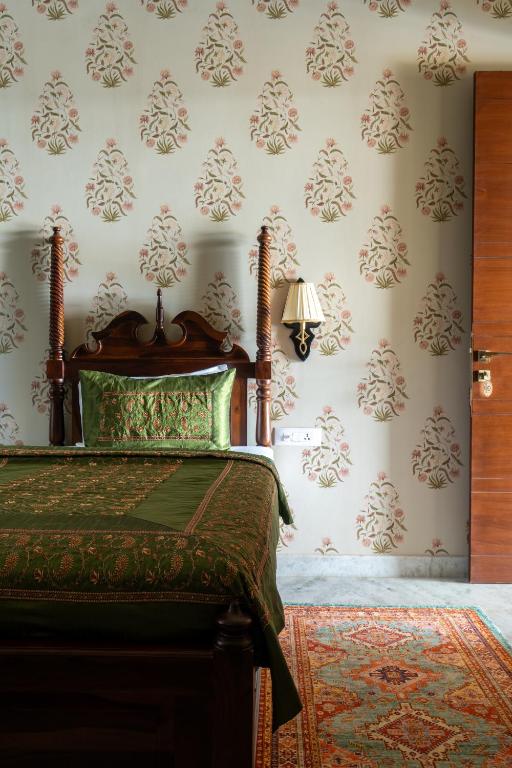 a bedroom with a bed and floral wallpaper at Dera Jaipur Homestay in Jaipur