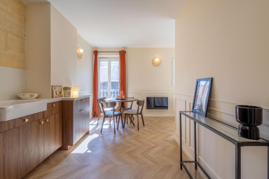 une cuisine et une salle à manger avec une table et des chaises dans l'établissement L'Intimiste Marché des Capucins, à Bordeaux