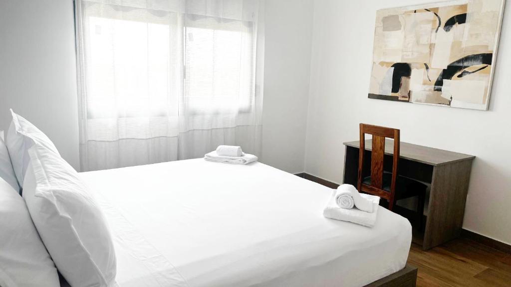 Un dormitorio con una cama blanca con dos toallas encima. en DakarByDays DBD011 Appartement Astou 3 chambres, en Dakar
