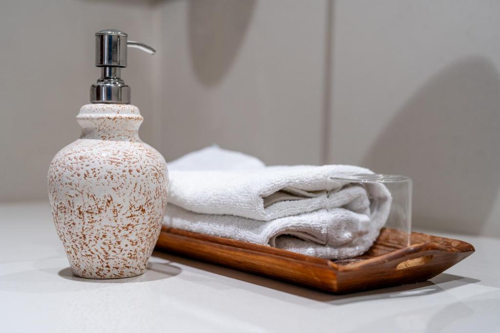 a bottle of soap and a wooden tray with towels at Dera Jaipur Homestay in Jaipur