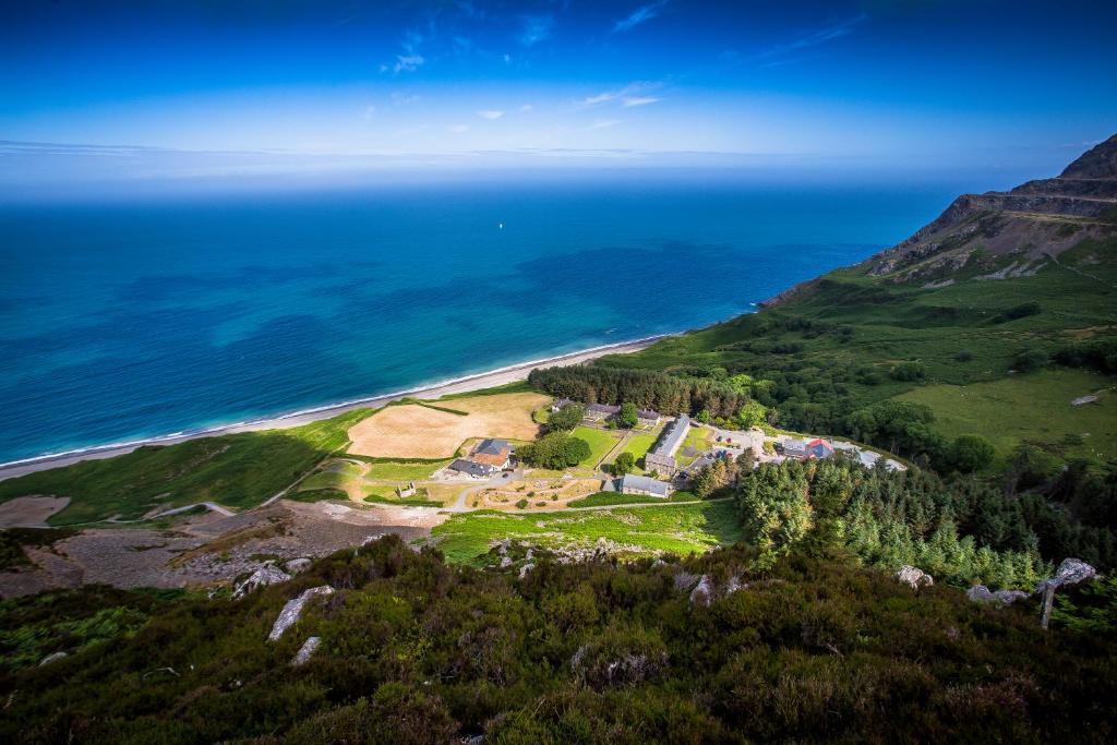 an aerial view of a house on a hill next to the ocean at Nant Gwrtheyrn in Llithfaen