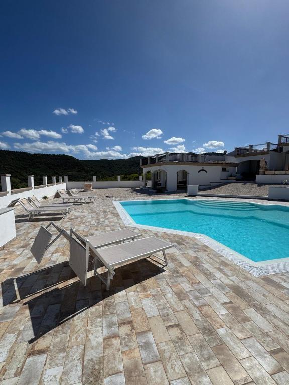 a swimming pool with a bench next to a building at Budoni residence Lutturai 4 in Budoni