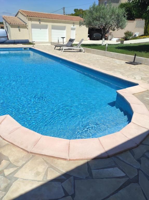 une piscine avec de l'eau bleue dans une cour dans l'établissement LA Marina, à Marcorignan