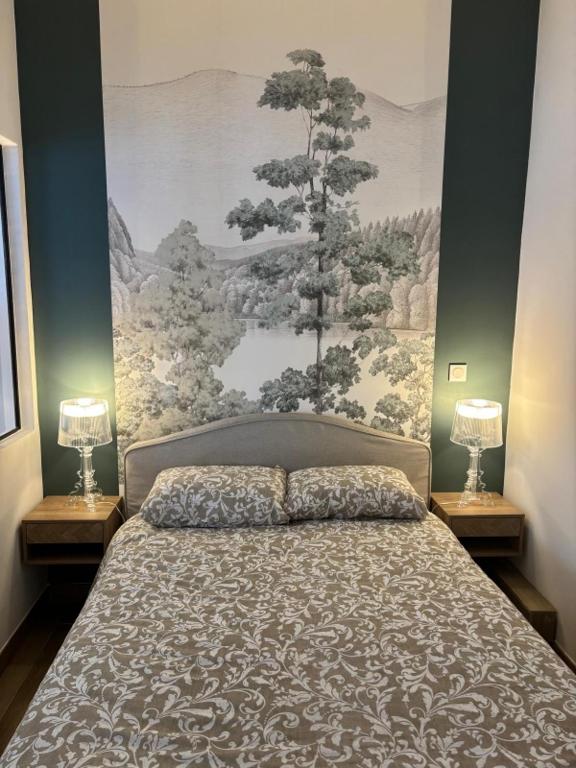 une chambre avec un lit avec un tableau sur le mur dans l'établissement Ravissant T2, proche centre, quartier très calme,,parking,clim, déco soignée, à Montpellier