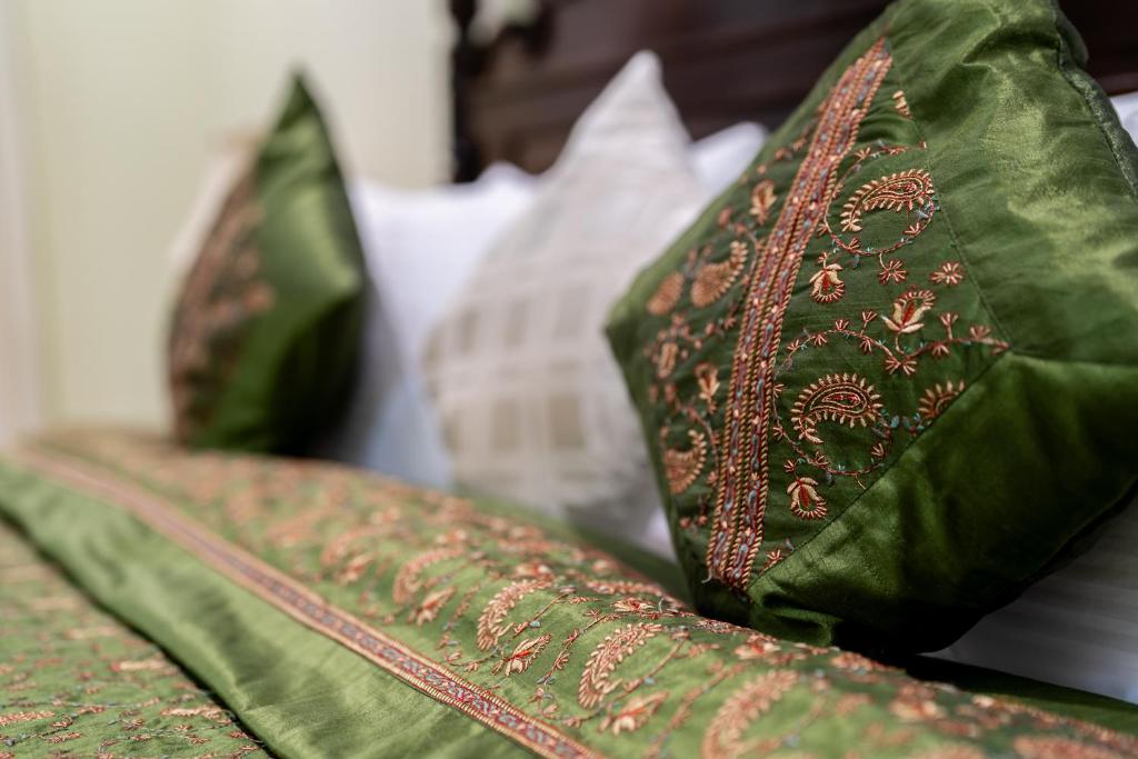 a row of green pillows sitting on a couch at Dera Jaipur Homestay in Jaipur