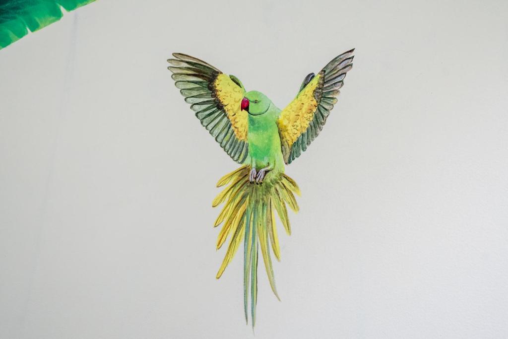 a green and yellow bird flying in the sky at Dera Jaipur Homestay in Jaipur