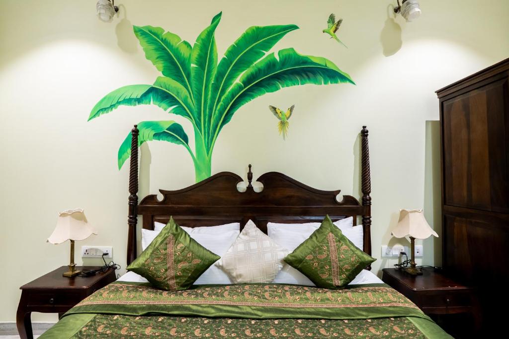 a bedroom with a bed with a large plant on the wall at Dera Jaipur Homestay in Jaipur