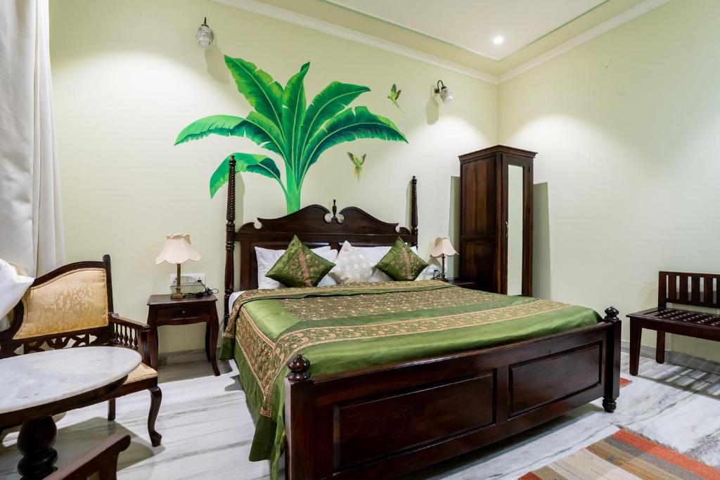 a bedroom with a bed with a palm tree on the wall at Dera Jaipur Homestay in Jaipur