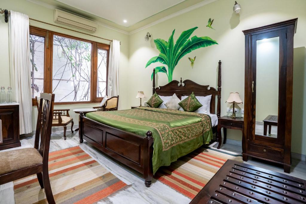 a bedroom with a bed with a green bedspread at Dera Jaipur Homestay in Jaipur