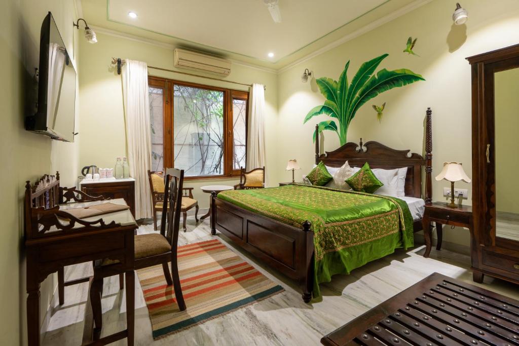 a bedroom with a bed and a table and a desk at Dera Jaipur Homestay in Jaipur