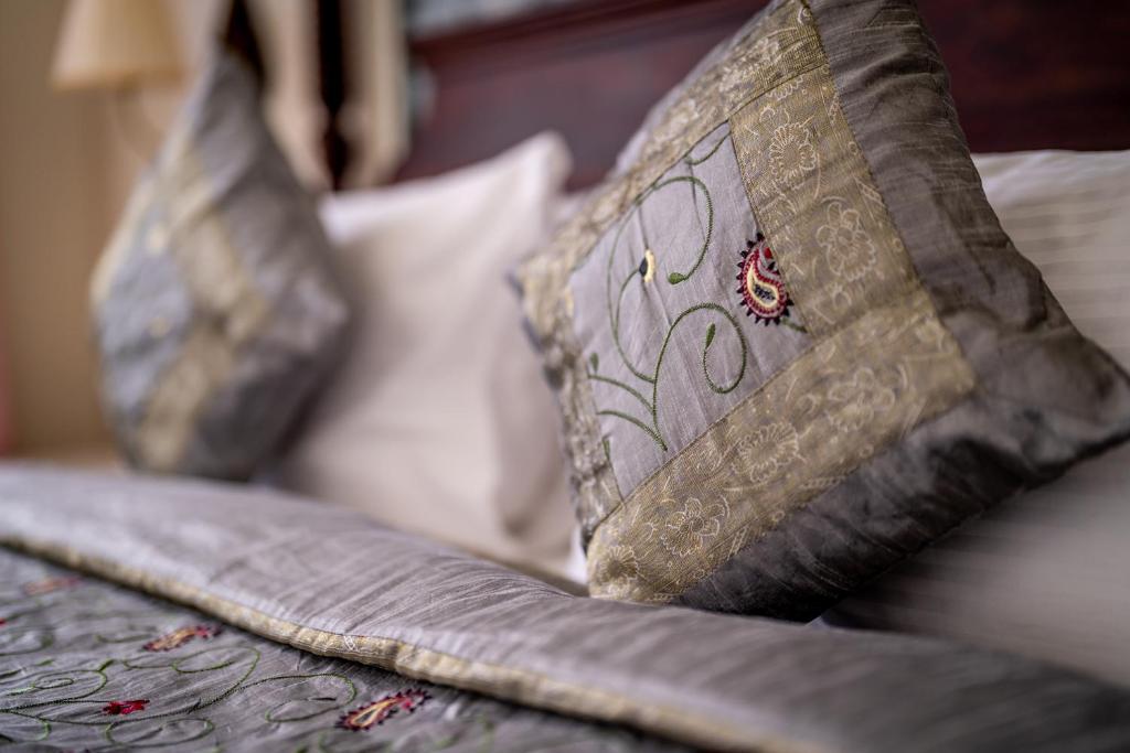a close up of two pillows on a bed at Dera Jaipur Homestay in Jaipur