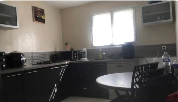 une cuisine avec une petite table et une fenêtre dans l'établissement Villa ensoleillée avec piscine route des plages, à Aimargues