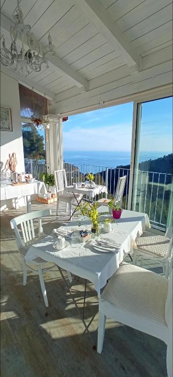 a white table and chairs on a patio at Message in a Bottle Bed and Breakfast in Camporosso