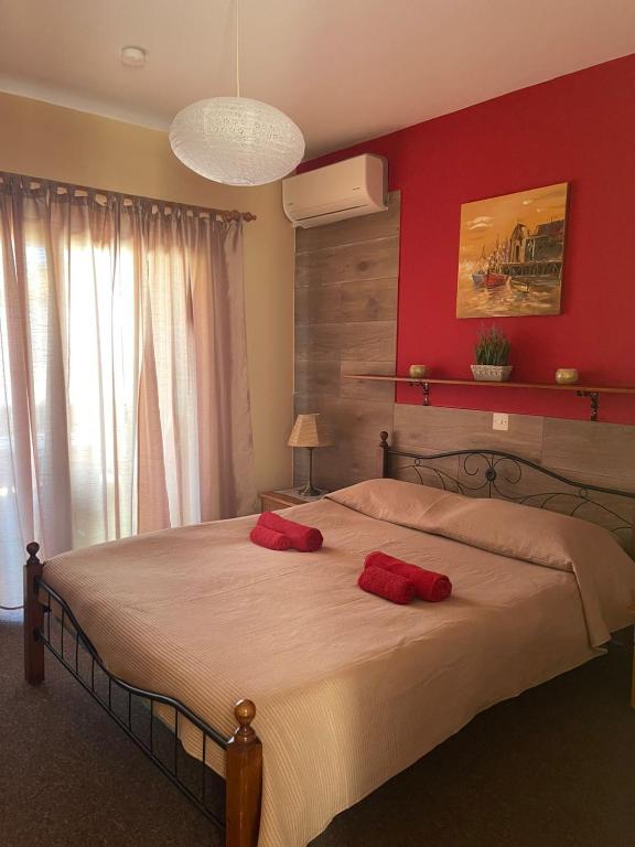 a bedroom with a large bed with two red pillows on it at Limnaria Westpark 2 bdrm apartment 122 in Paphos