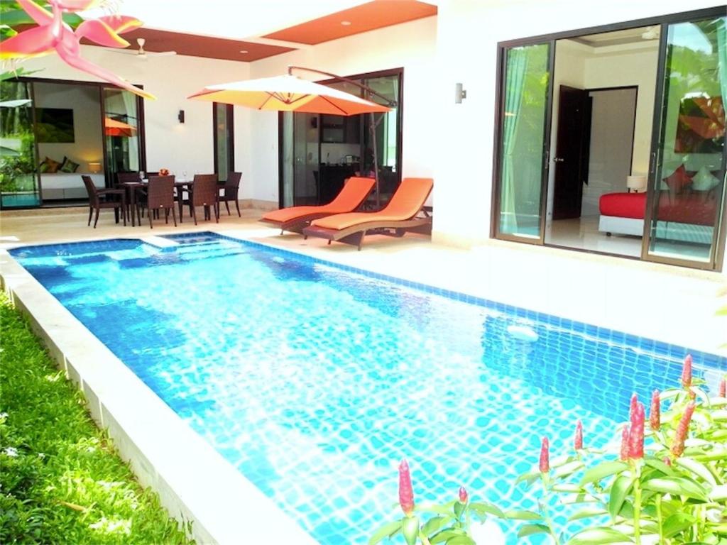 a swimming pool in the backyard of a house at Intira Villa Rawai 2 bedrooms Villa in Rawai Beach