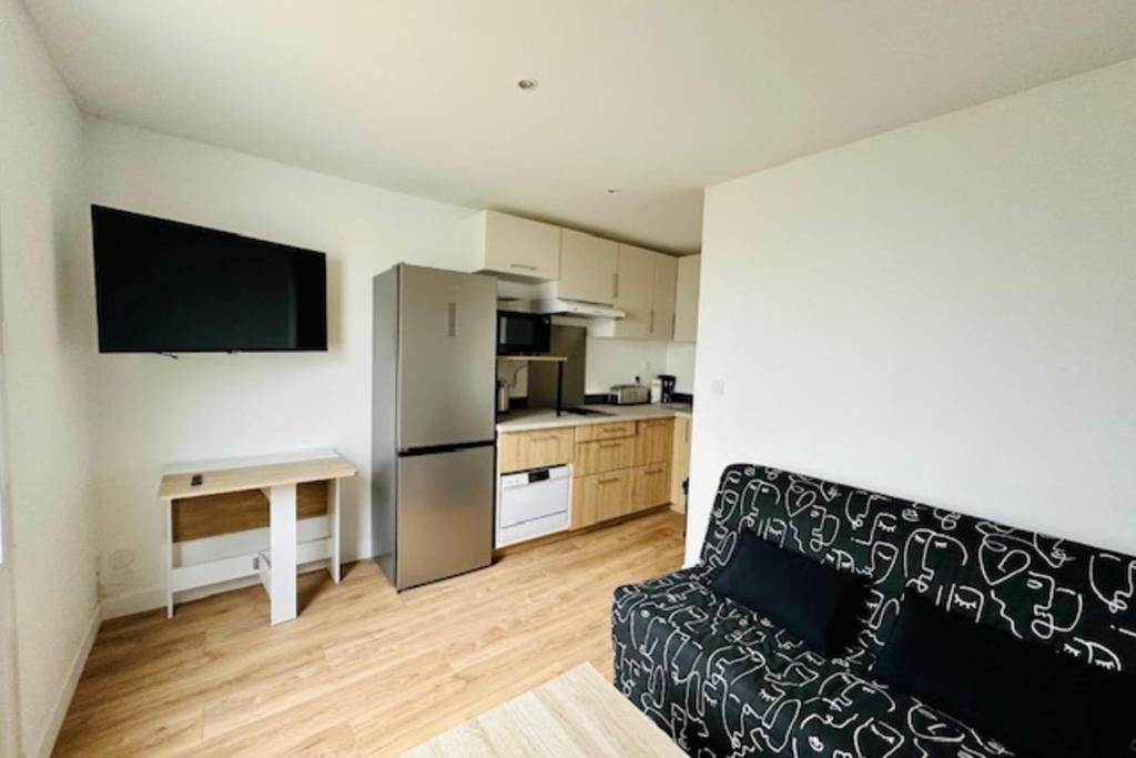 un salon avec un canapé et une cuisine dans l'établissement Apartment 2 rooms with garden in La Rochelle, à La Rochelle