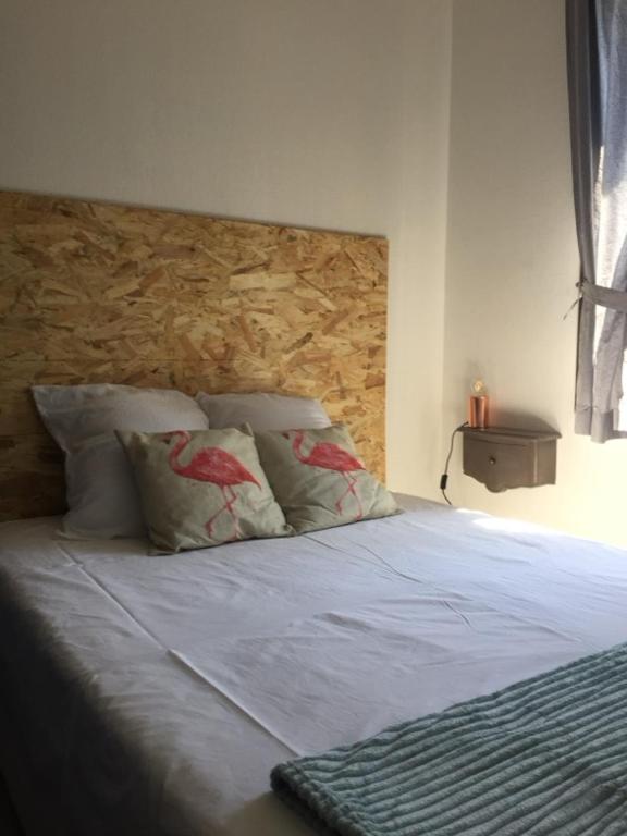 un lit avec deux oreillers dessus dans une chambre dans l'établissement T2 Piscine, parking et clim à sanary, à Sanary-sur-Mer