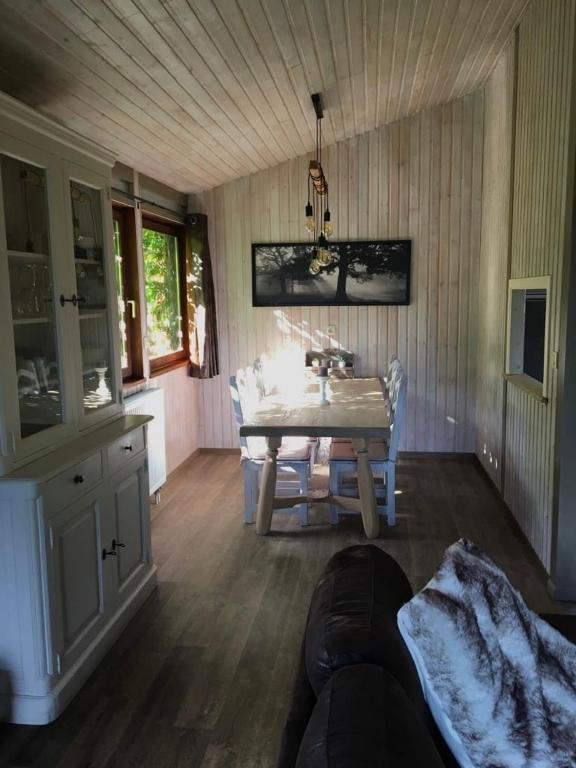a living room with a table and a dining room at Chalet le Faye in Waimes