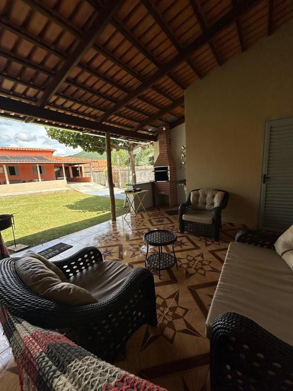 a living room with a bed and chairs and a patio at Rancho Do Claudim in Pirenópolis