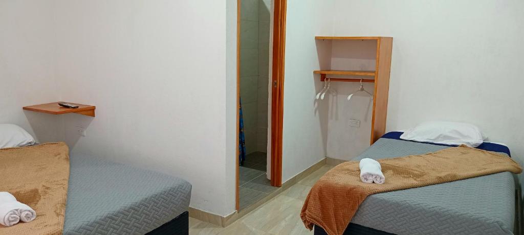 una piccola stanza con due letti e uno specchio di Bambu Hostel a San Francisco