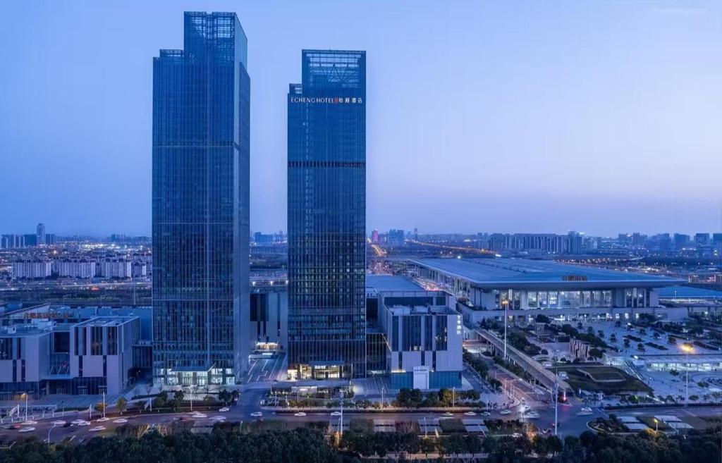 two tall skyscrapers in a city at night at Hefei High-Speed Railway South Station North Square Yicheng Hotel in Hefei