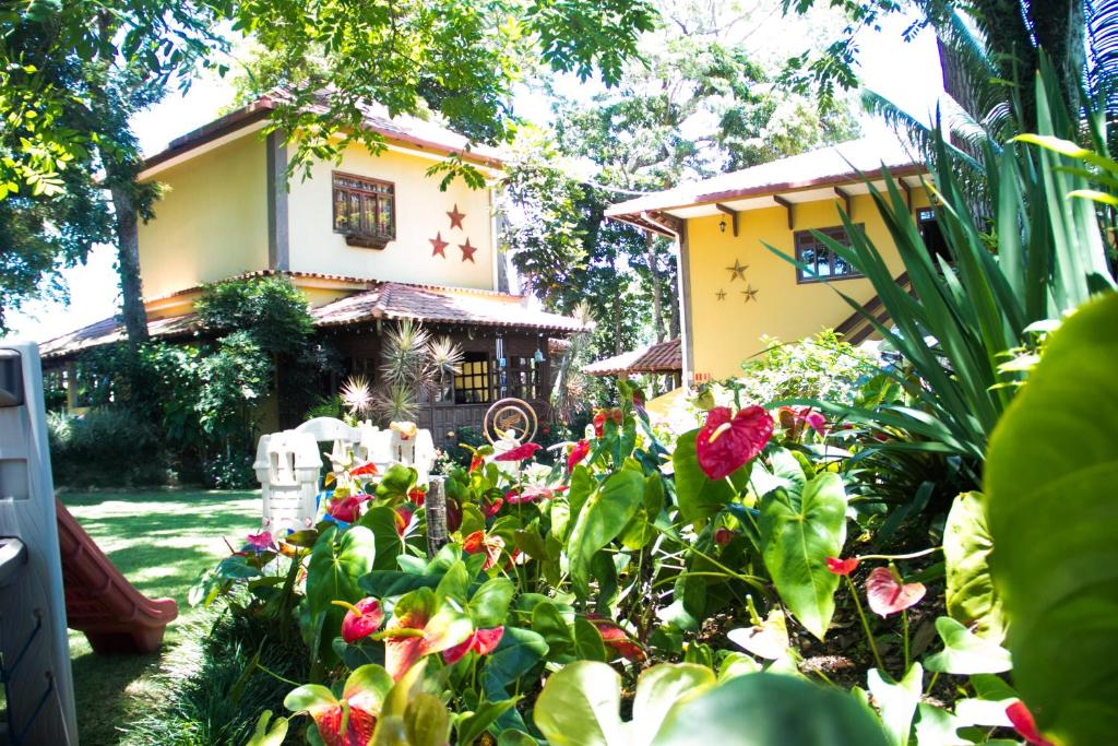 un jardín con flores frente a una casa en Pousada da Mata, en Iriri