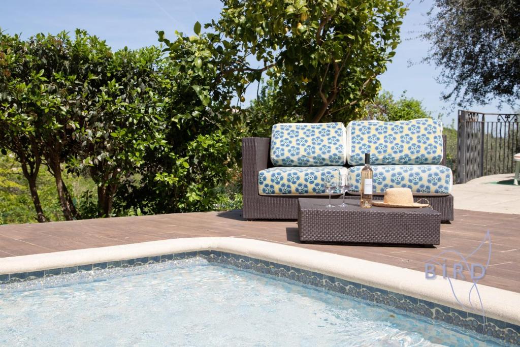 - un canapé et des chaises à côté de la piscine dans l'établissement Pretty villa in greenery ecrin, à Le Rouret