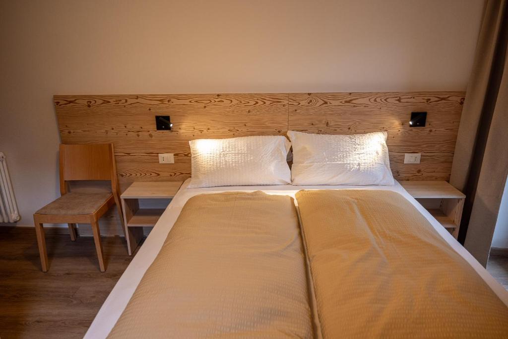 Postel nebo postele na pokoji v ubytování SAN PIETRO DOLOMITI Small Budget Hotel