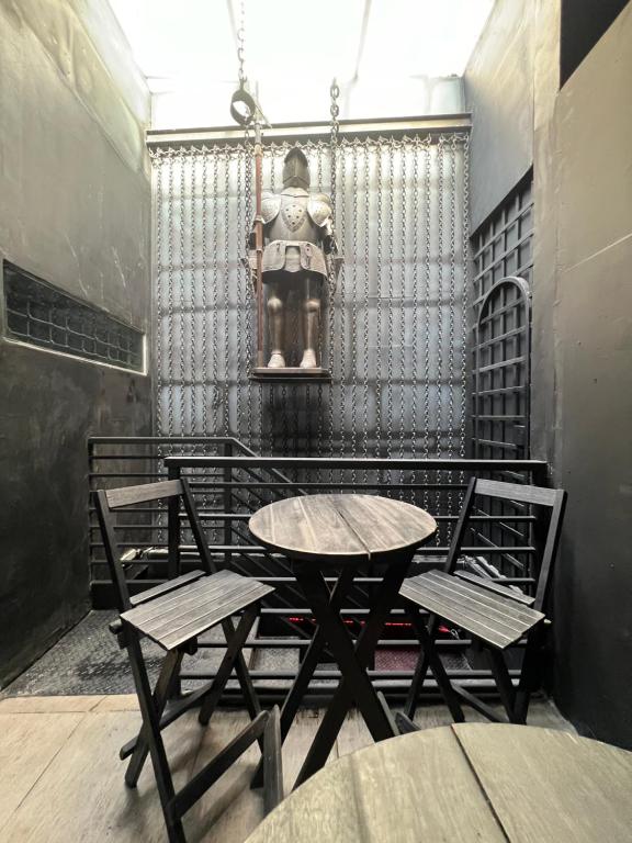 Una mesa y sillas en una habitación con una estatua. en Castle of Vibes - Hostel, en Río de Janeiro