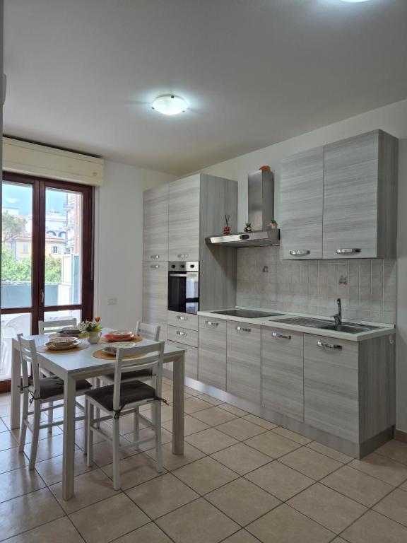 a kitchen with a table and a table and chairs at Appartamento a 100m dal mare in Grottammare