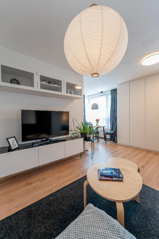 a living room with a large television and a table at Bastion New Apartment with Parking in Košice