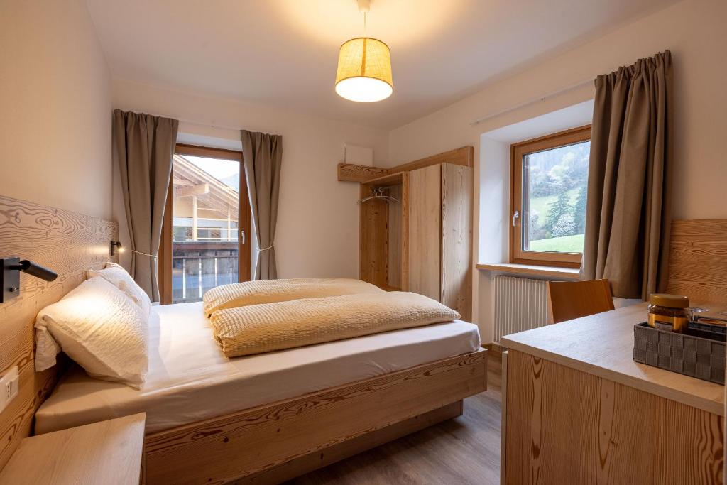 Postel nebo postele na pokoji v ubytování SAN PIETRO DOLOMITI Small Budget Hotel