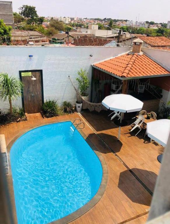 a large blue swimming pool on a wooden deck at Flat do Bispo in Uberlândia