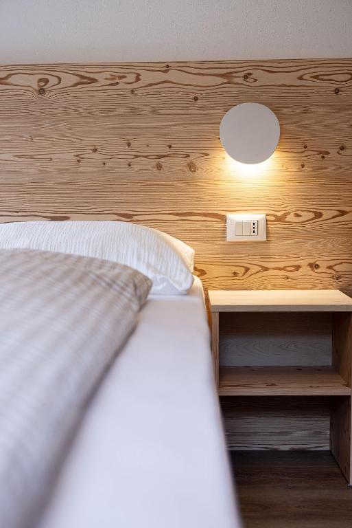 Postel nebo postele na pokoji v ubytování SAN PIETRO DOLOMITI Small Budget Hotel