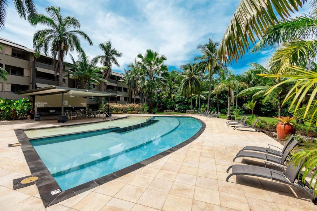 克瓦拉海滩Kewarra Beach Paradise 1BR Resort Style Apt - Pool的度假村内的游泳池,带椅子和棕榈树