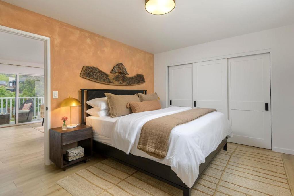 a bedroom with a large bed and a sliding glass door at Bali Home and SB Beaches in Summerland