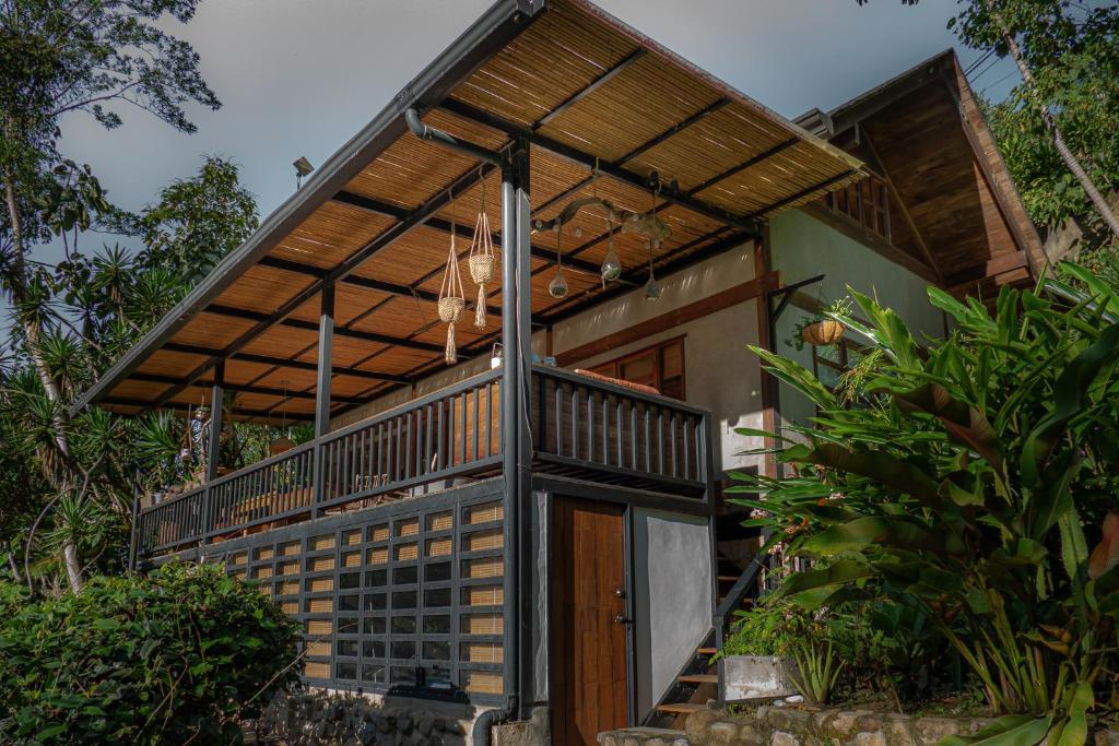 a house with a wooden door and a balcony at Charming Cosy Chirripó Mountain Riverfront Cottage in Canaán