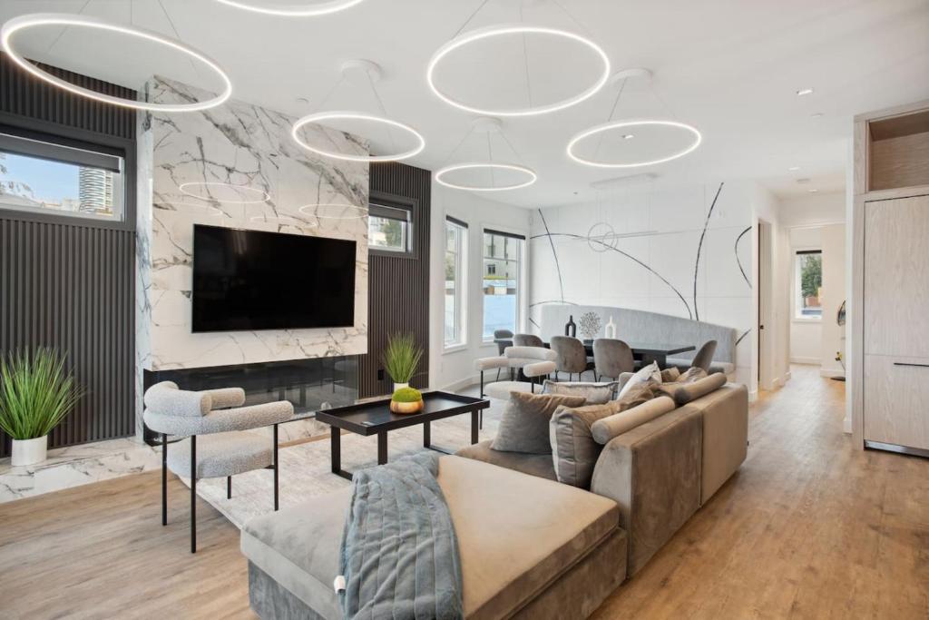 ein Wohnzimmer mit Sofas und Fernseher in der Unterkunft Luxury Downtown Vancouver Home Near Sunset Beach with Parking in Vancouver