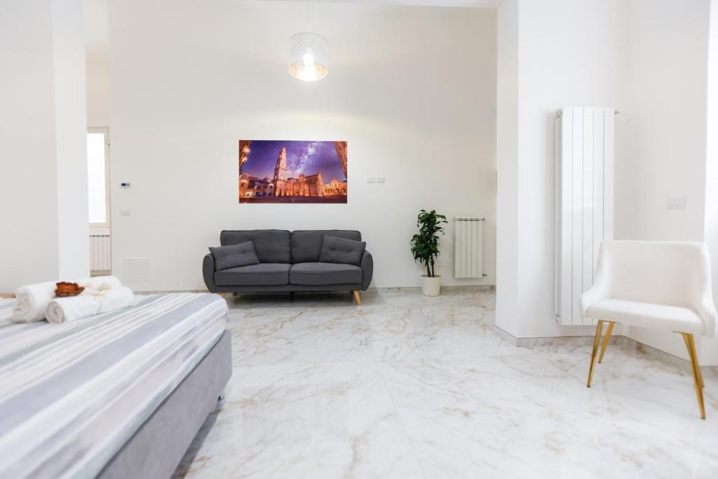un soggiorno bianco con divano e letto di Elegante Suite con giardino nel centro Lecce - Free Parking - WiFi a Lecce