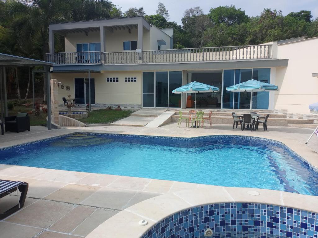 a swimming pool in front of a house at Casa Campestre en Condominio en Anapoima in Anapoima