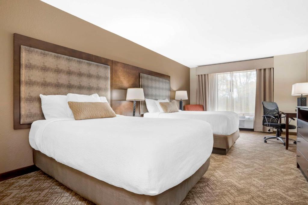 a hotel room with two beds and a desk at Best Western Gardendale in Gardendale
