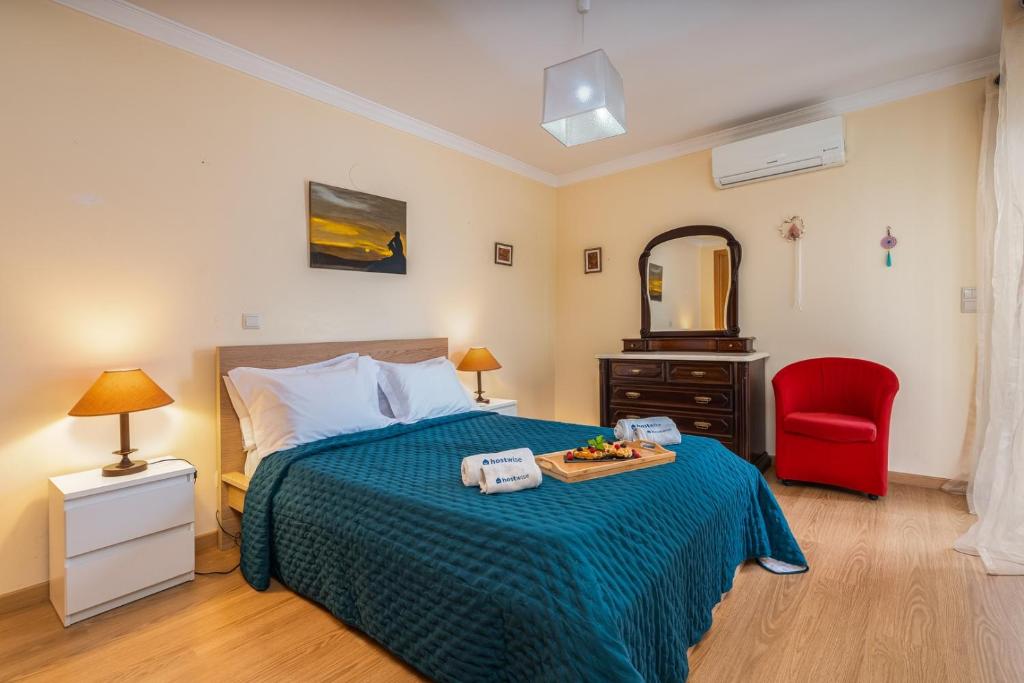 una camera da letto con un letto e una sedia rossa di Bright & Spacious Flat by HostWise a Vila Real de Santo António