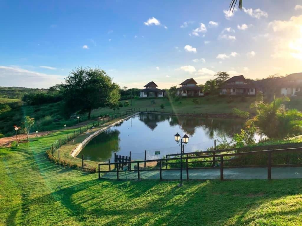 a pond in a park with houses in the background at Winterville Residence Gravatá por Yolo in Gravatá