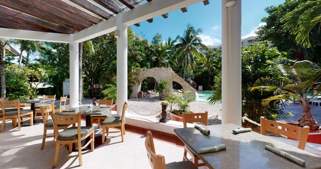 a patio with tables and chairs and a view of a pool at Grand Park Royal Cozumel - All Inclusive in Cozumel