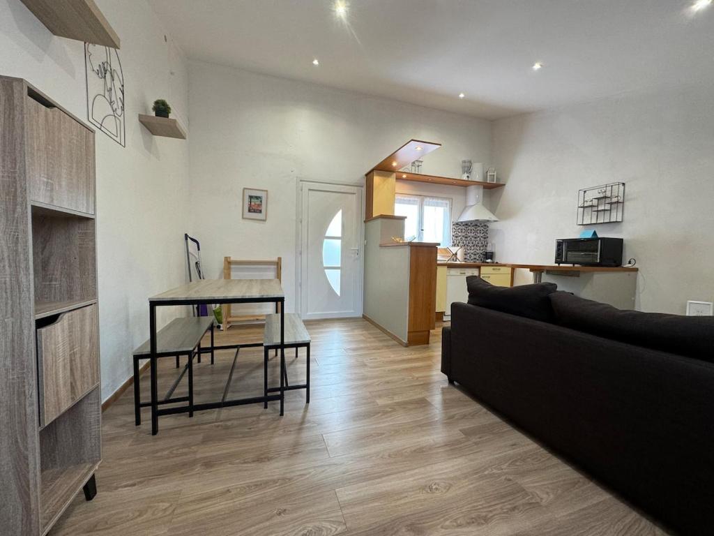 a living room with a couch and a table at Chez Zelie in Canet-en-Roussillon