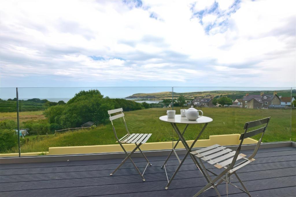 Una mesa y sillas en un balcón con vista. en The Willows, en Newport