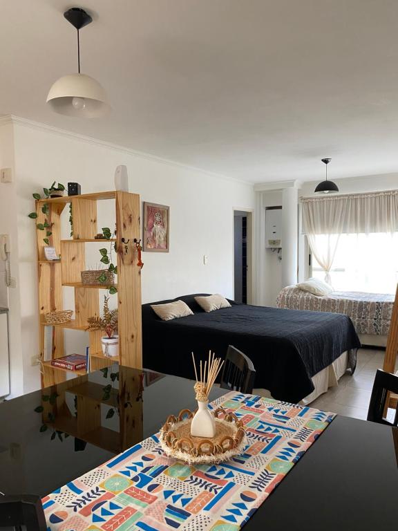 Un dormitorio con una cama y una mesa en una habitación. en Departamento monoambiente Barrio Martin, en Rosario