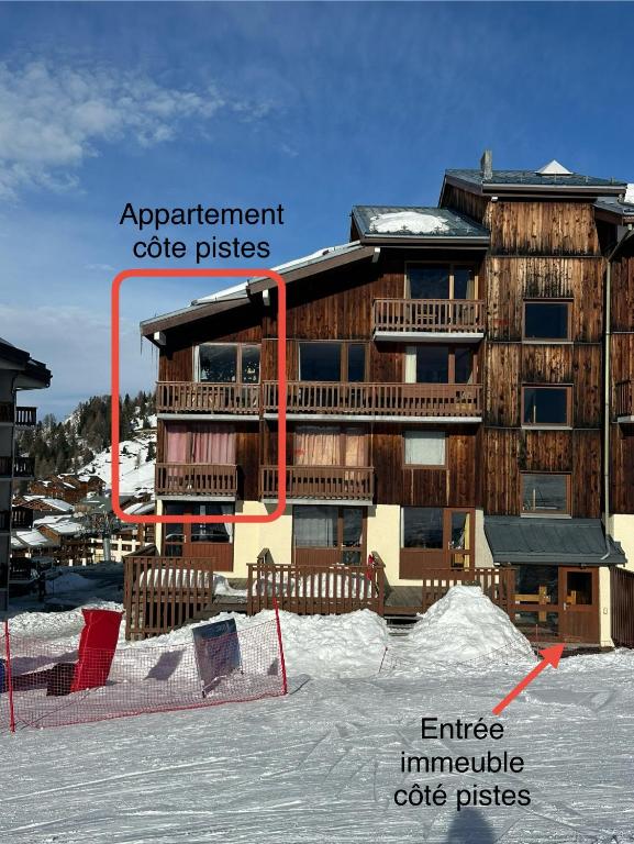 un bâtiment dans la neige devant un bâtiment dans l'établissement Appartement station de ski la plagne, à La Plagne Tarentaise
