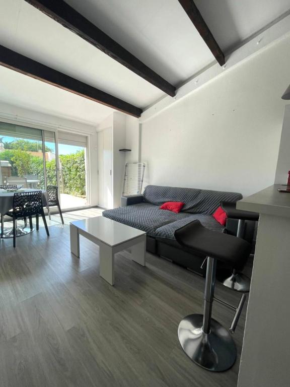 un salon avec un lit et une table dans l'établissement Maison Paisible - 4pers - Histoire de clés, au Cap d'Agde